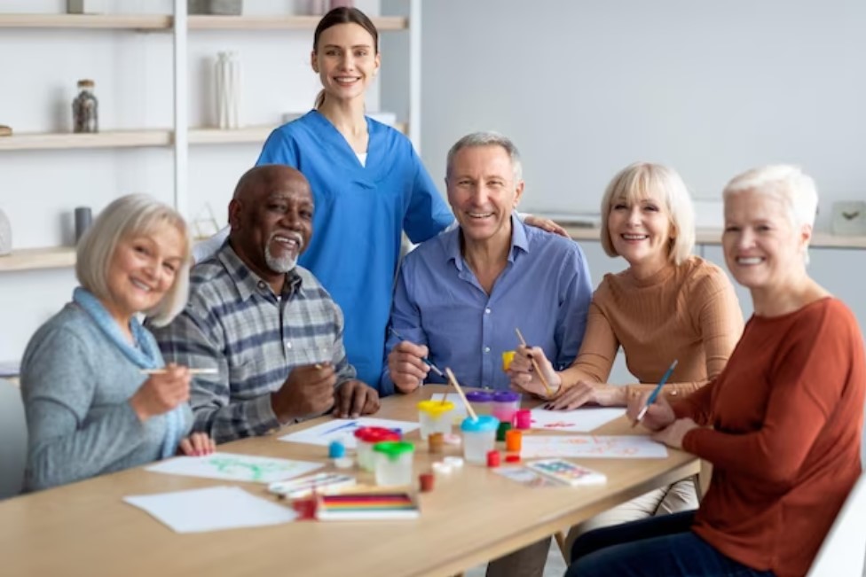 Terapeuta com turma de idosos aplicando atividade de pintura